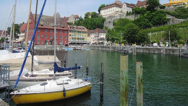 A marina with boats docked, a yellow boat in the foreground, and buildings with balconies in the background. - Apartment Bears, Meersburg (Meersburg)