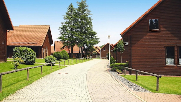 A pathway leading to wooden buildings with a clear sky. - Familienfreundliches Ferienhaus mit Wlan in Hasselfelde (Oberharz am Brocken)