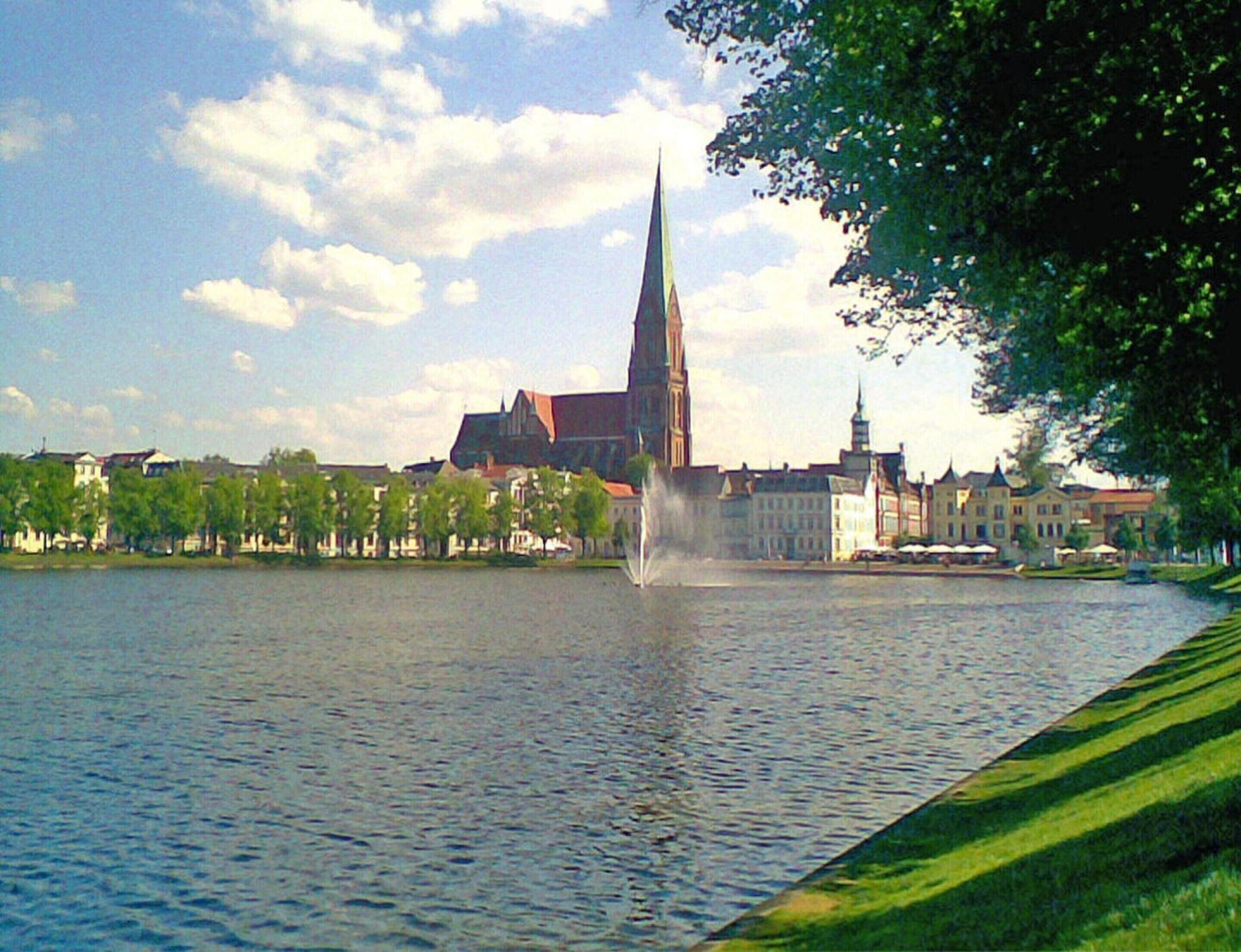 A river with a church spire in the background.