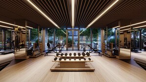 Ein modernes Fitnessstudio mit Holzböden, Spiegelwänden und Trainingsgeräten.