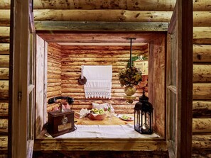 A rustic wooden cabin interior with a dining area, a vintage radio, and a hanging light fixture. - Maximilian Apartmenthaus 2-6 People (Neukirchen am Grossvenediger)