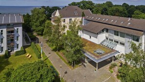 Un bâtiment moderne doté d’un toit plat, de panneaux solaires et d’un espace extérieur couvert avec un toit en verre.