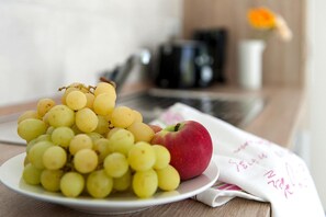 A plate with yellow grapes and a red apple on a white plate, with a cloth with writing underneath. - Gemutlicher Bungalow in Storkow am See (Storkow)