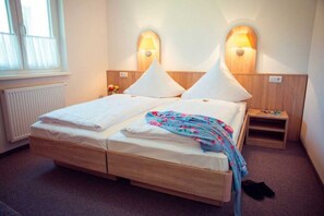 A double bed with a wooden headboard, two bedside lamps, a small bedside table, and a radiator. - Gemutlicher Bungalow in Storkow am See (Storkow)