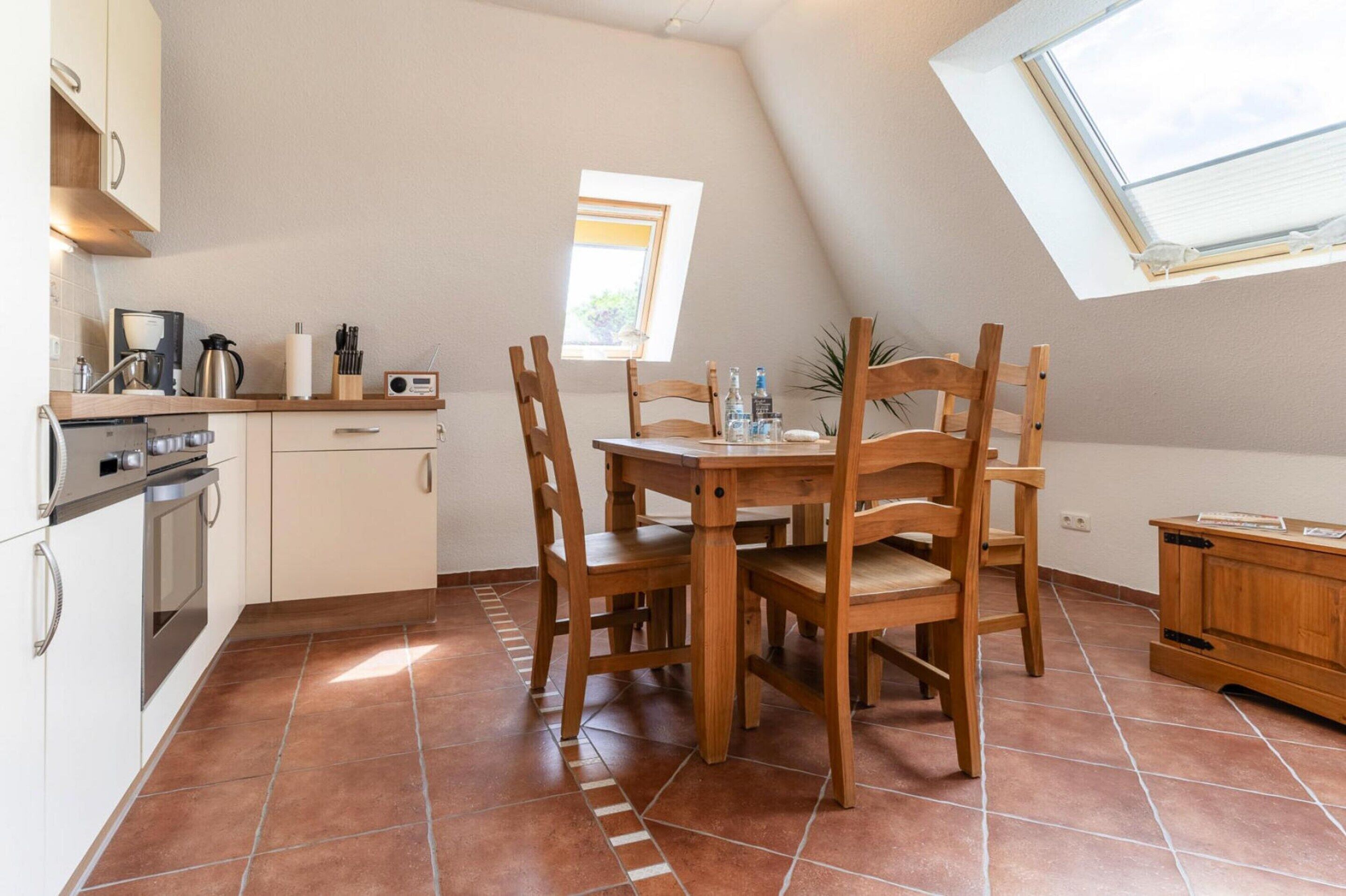 A kitchen with a dining table, chairs, and a small window.
