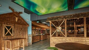 A rustic-themed bar with wooden furniture and a ceiling display of the northern lights. - Holiday Home in Damp With Garden (Damp)