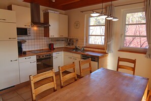 Enjoy meal preparation and dining in this compact kitchen with appliances and a dining area.