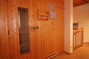 Una puerta de madera con un panel de vidrio, un estante pequeño y un cartel en la pared.
