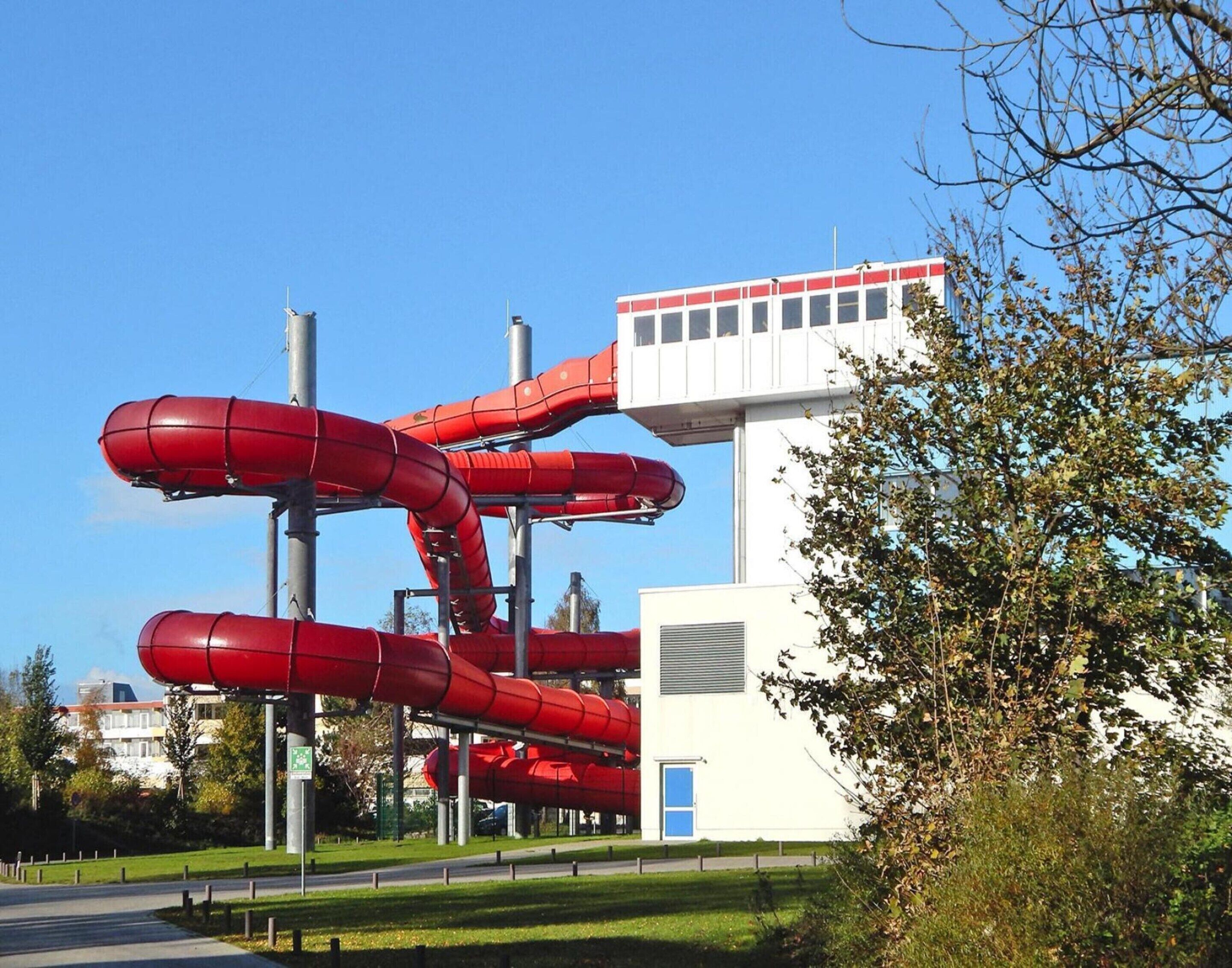 A building with a unique architectural design featuring multiple red cylindrical structures.