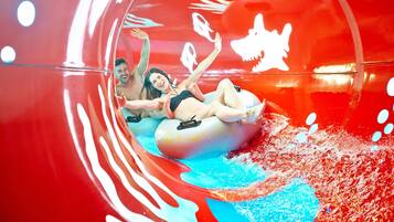 A water slide with a transparent tube and a red interior.