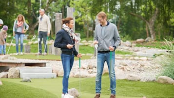 En golfbana med golfspelare och en puttinggreen.