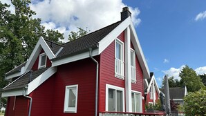 A red house with a white porch and a chimney. - Doppelhaushalfte Dunenrose, Glowe (Glowe)