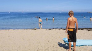 A beach with people swimming and standing in the water. - Doppelhaushalfte Dunenrose, Glowe (Glowe)