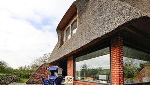 A house with a steeply pitched roof, large windows, and a brick exterior. - Ferienhaus am Watt, List auf Sylt (List)