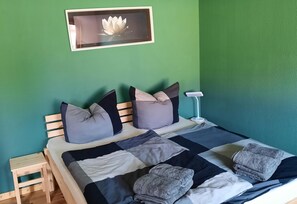 Ein Bett mit einer Decke, Kissen und einem Nachttisch.