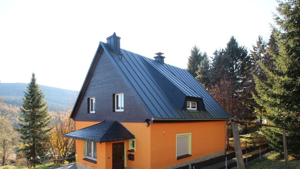 A house with a steep gabled roof, a small porch, and a window with a shutter. - Ferienhaus, Oberwiesenthal (Oberwiesenthal)