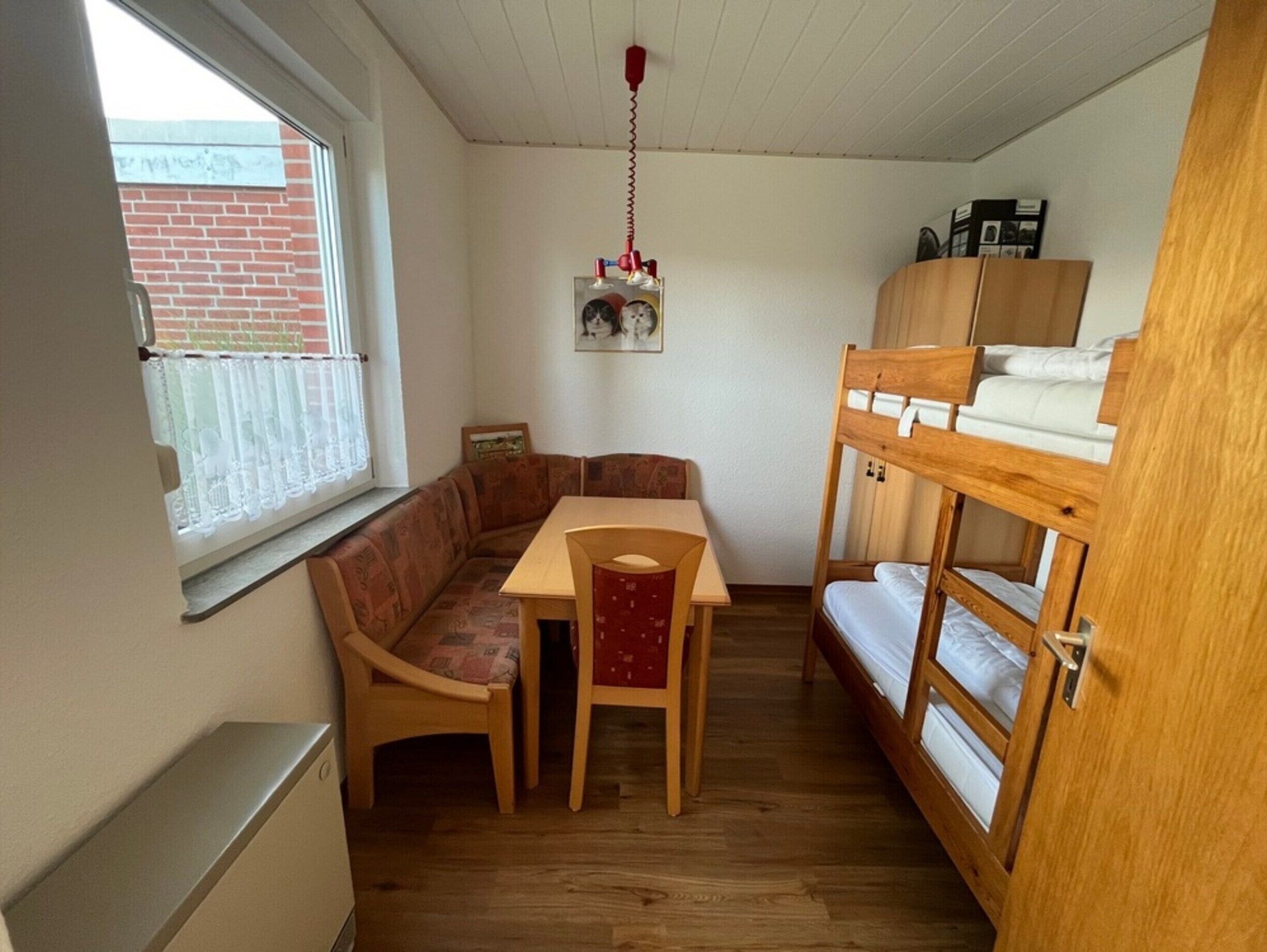 Une petite pièce comprenant un lit superposé en bois, une petite table et un canapé.