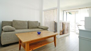 A living room with a wooden coffee table, a grey sofa, and a white cabinet. - Ferienwohnung Seeblick, Malchow (Malchow)