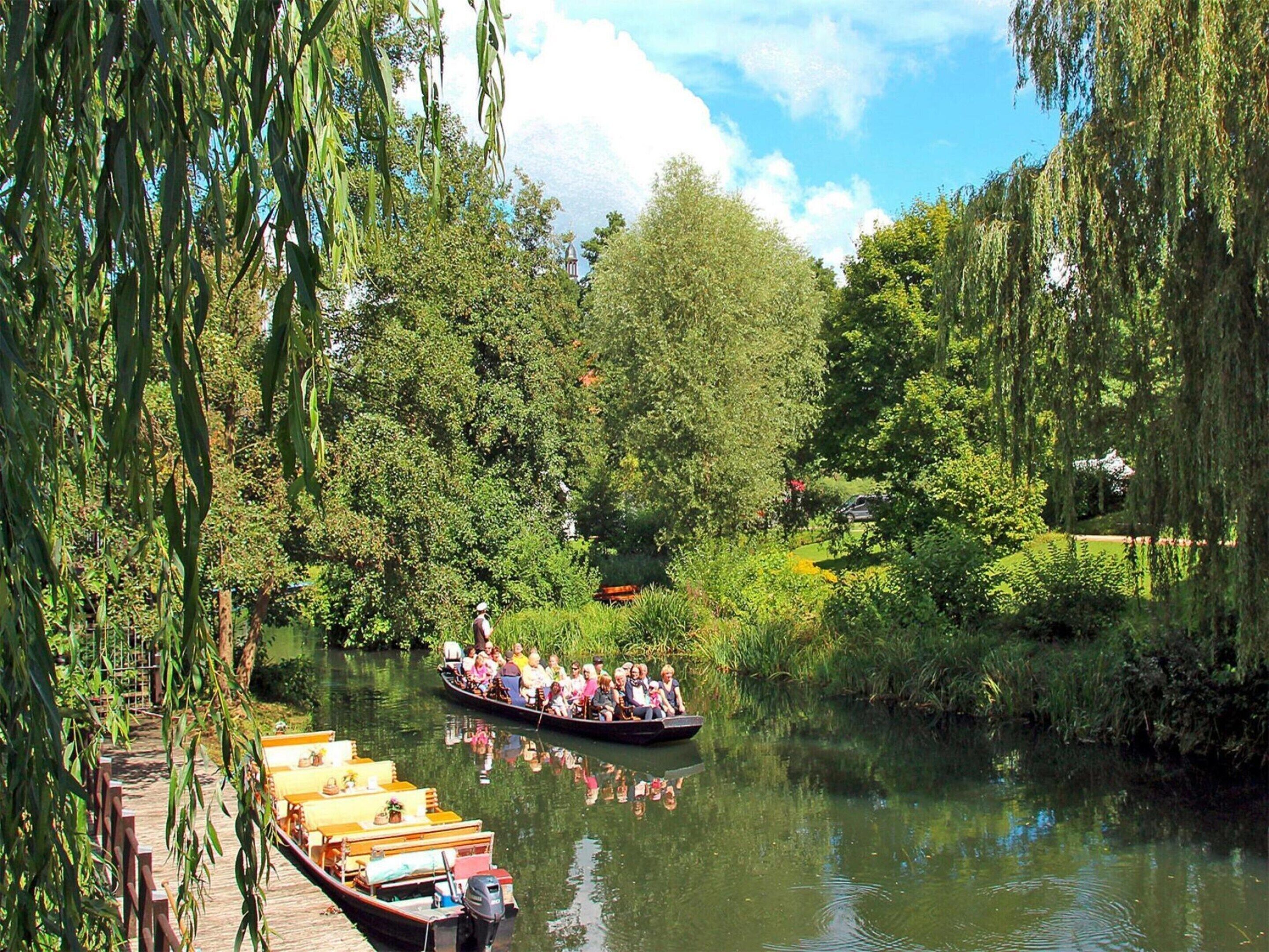 A river with boats and a wooden walkway.