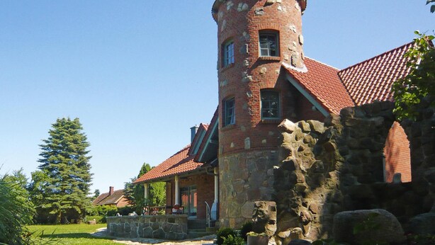 A historic building with a tower, stone walls, and a red-tiled roof. - Ferienhaus, Plau am See (Plau am See)
