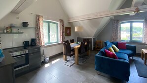 A compact living space with a kitchen, dining area, and a blue sofa. - Ferienhaus, Plau am See (Plau am See)