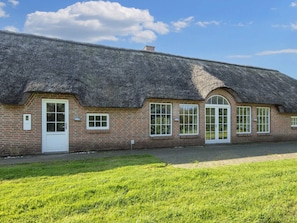 A traditional thatched-roof building with a brick facade, multiple windows, and a door. - 4 Star Holiday Home in Ulfborg (Ulfborg)