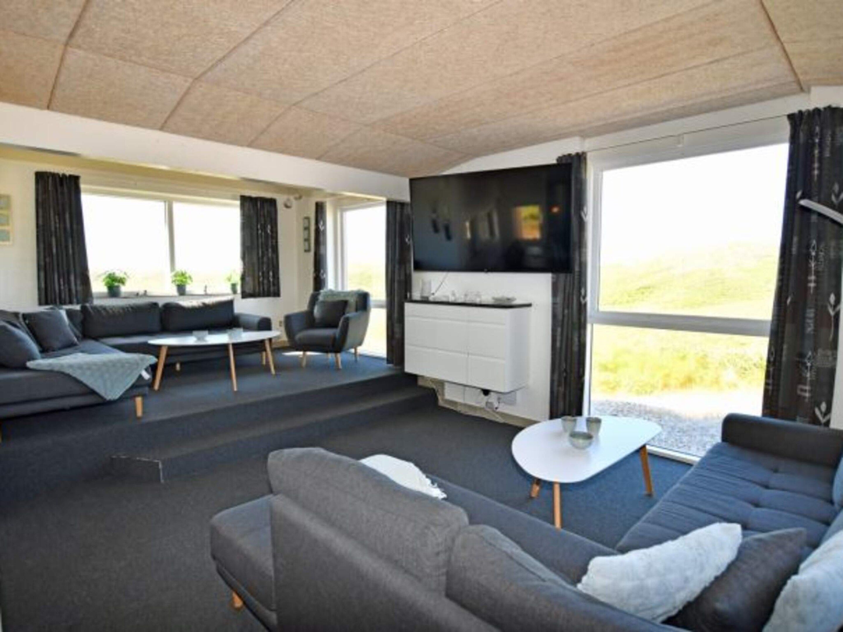 A modern living room with a sofa set, a coffee table, and a television.