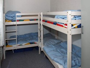 A bunk bed room with a grey carpet, white walls, and a door on the right. - 4 Star Holiday Home in Ringkobing (Ringkobing)