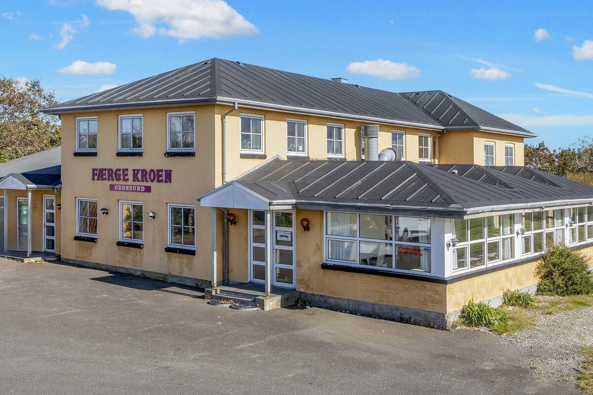 A two-story building with a sign reading 'FARGE KROEN ODESUND.'