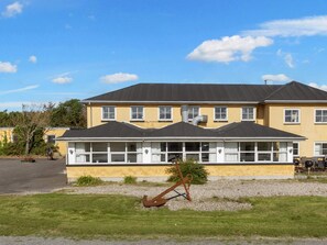 A two-story building with a yellow facade and a black roof. - 26 Person Holiday Home in Thyholm (Thyholm)
