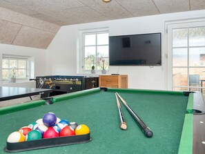 A billiards room with a pool table, billiard balls, a foosball table, and a television. - 4 Star Holiday Home in Ulfborg (Ulfborg)
