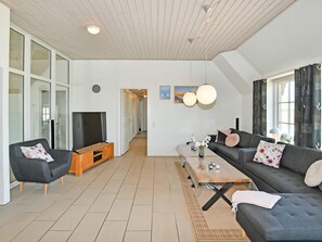 A modern living room with a sofa, a coffee table, and a television. - 4 Star Holiday Home in Ulfborg (Ulfborg)