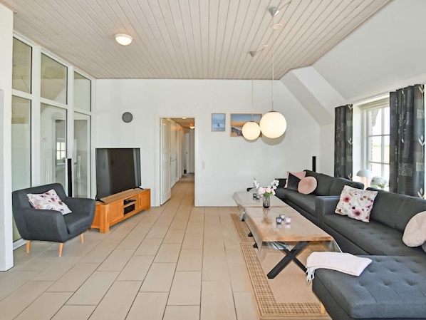 A modern living room with a sofa, a coffee table, and a television.