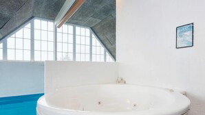 A large indoor swimming pool with a hot tub in the foreground. - 4 Star Holiday Home in Harboore (Harboore)