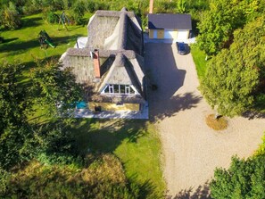 A house with a thatched roof, a visible swimming pool, and a driveway leading to a parked car. - 4 Star Holiday Home in Karup J (Karup)