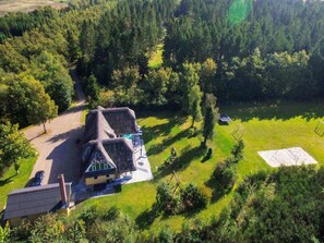A house with a thatched roof, surrounded by a forested area and a small lawn. - 4 Star Holiday Home in Karup J (Karup)