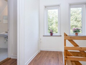 A room with two windows, a wooden bench, and a potted plant on the windowsill. - 18 Person Holiday Home in Skjern (Skjern)