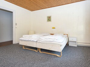 A bedroom with a bed, a bedside table, a lamp, and a small cabinet. - 18 Person Holiday Home in Skjern (Skjern)