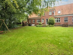 A brick house with a well-maintained lawn and a swing set. - 18 Person Holiday Home in Skjern (Skjern)