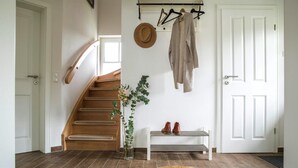 A staircase leading to a landing with a bench and a hanging coat rack. - Ferienhaus in Fuhlendorf (Fuhlendorf)