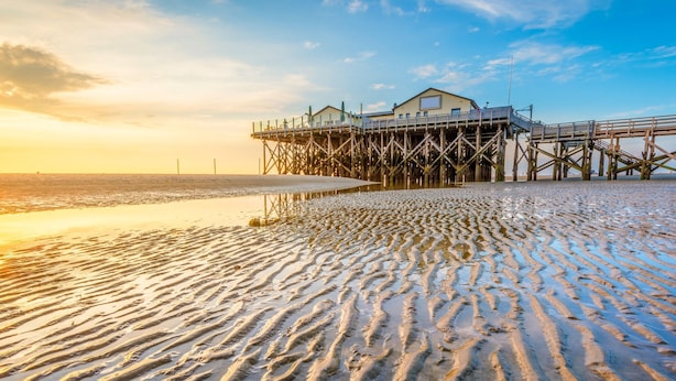 A pier extending into the water with a building at the end. - Renovierte Ferienwohnung, St. Peter-ording (St. Peter-Ording)