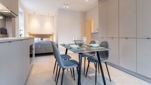 A modern kitchen with a dining area, a bed, and a view of the city. - Renovierte Ferienwohnung, St. Peter-ording (St. Peter-Ording)