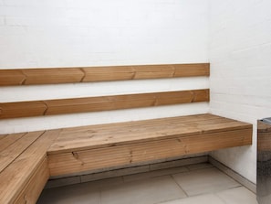 A wooden bench with a slatted design against a white wall. - 4 Star Holiday Home in Ulfborg (Ulfborg)