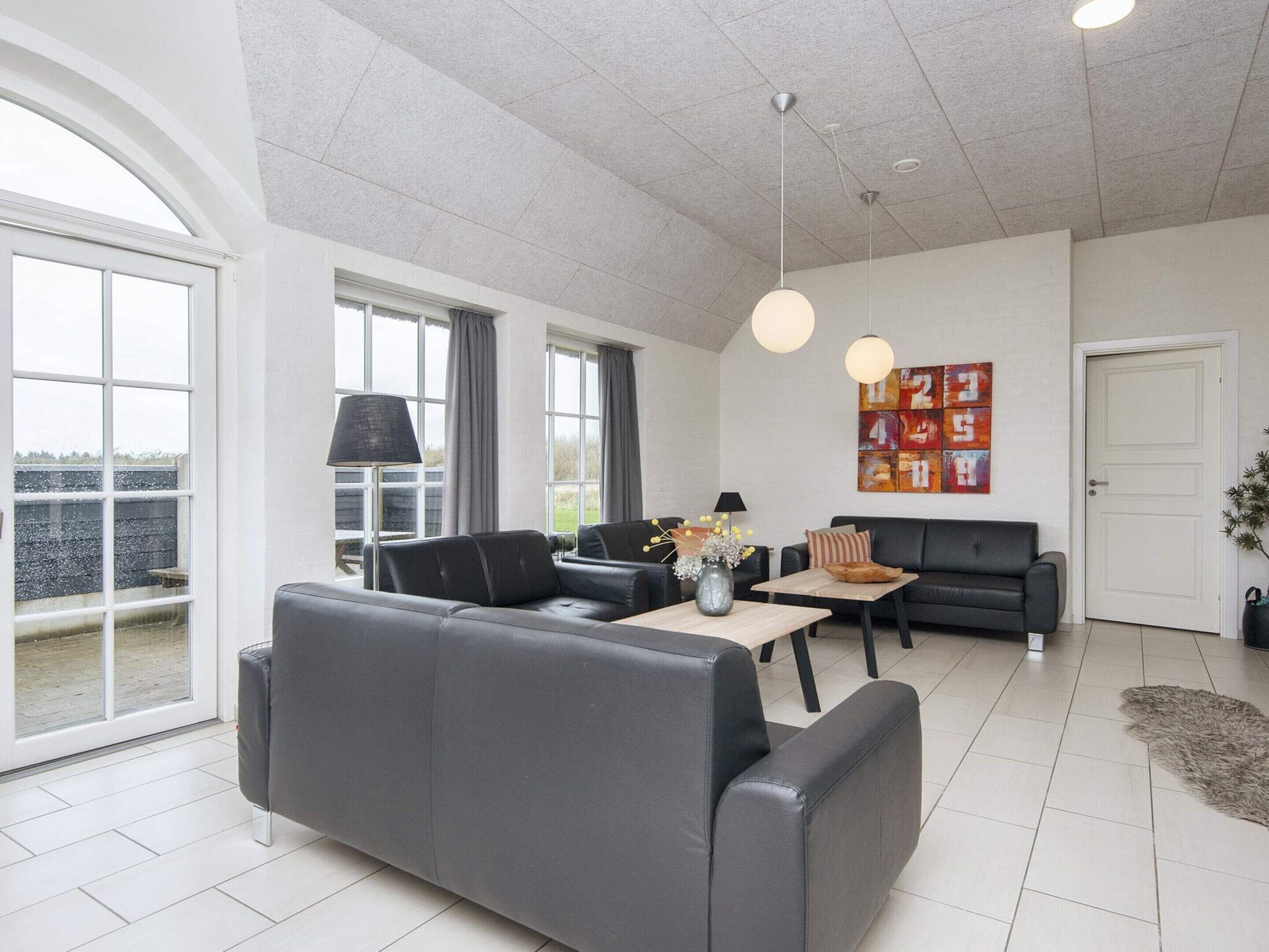 Ein modernes Wohnzimmer mit einer Couch, einem Couchtisch und einem Bild an der Wand.