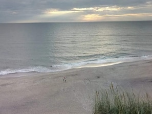 A beach with a wide sandy shore and gentle waves.