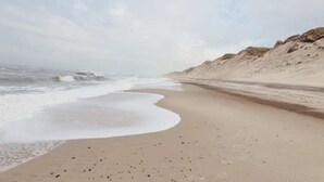 A beach with a sandy shore and waves crashing onto it. - 4 Star Holiday Home in Ulfborg (Ulfborg)