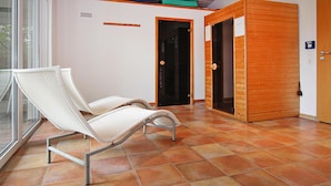 A room with two white wicker chairs, a wooden door, and a tiled floor. - Ferienhaus fur 21 Personen im Mueritz Nationalpark (Mirow)