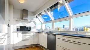 A modern kitchen with white cabinetry, a black dishwasher, and a skylight. - 6 Person Holiday Home in Fano (Fano)