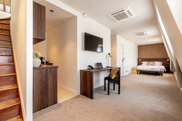 Une chambre à coucher moderne avec un bureau en bois, un ordinateur portable et un lit.