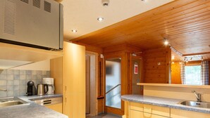 Eine kompakte Küche mit Granit Arbeitsplatten, Edelstahlgeräten und Holzschränken.